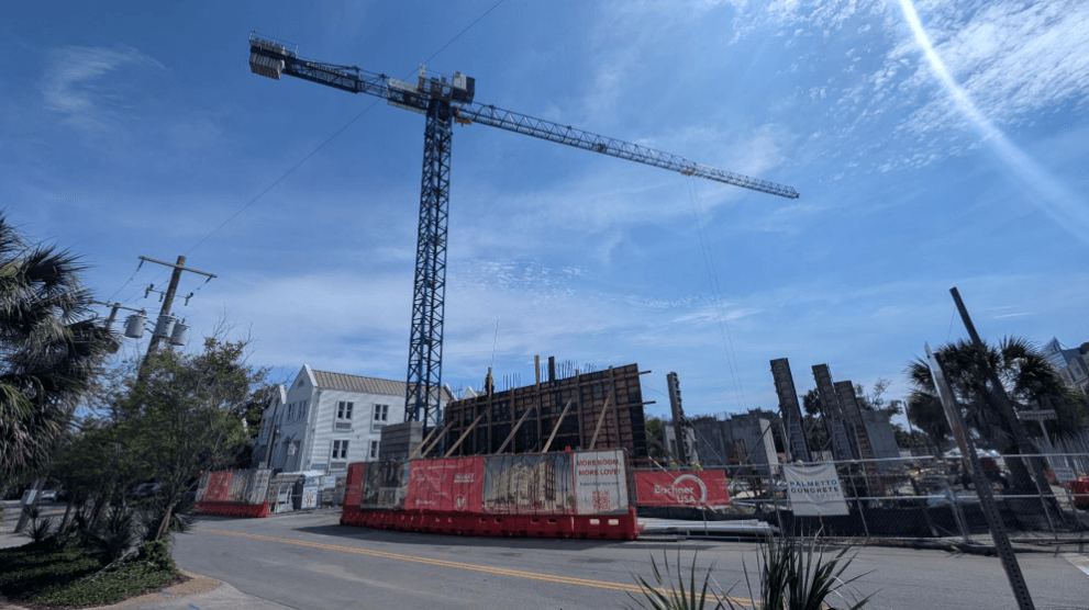 a new transformer in place to support both buildings, shear walls steadily rising across the site, and elevator shafts taking shape